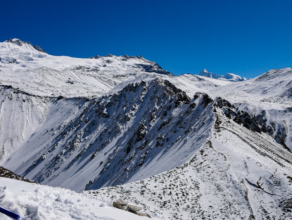 uma montanha coberta de neve com um céu azul ao fundo