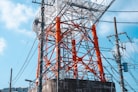 an orange and white tower sitting next to power lines