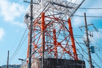 an orange and white tower sitting next to power lines