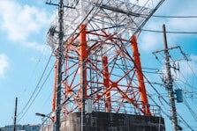 an orange and white tower sitting next to power lines