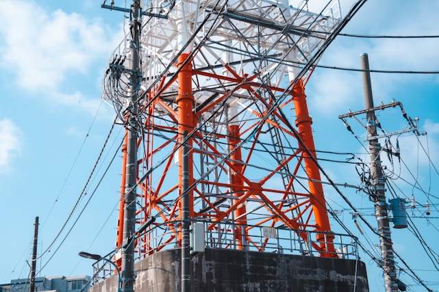 an orange and white tower sitting next to power lines