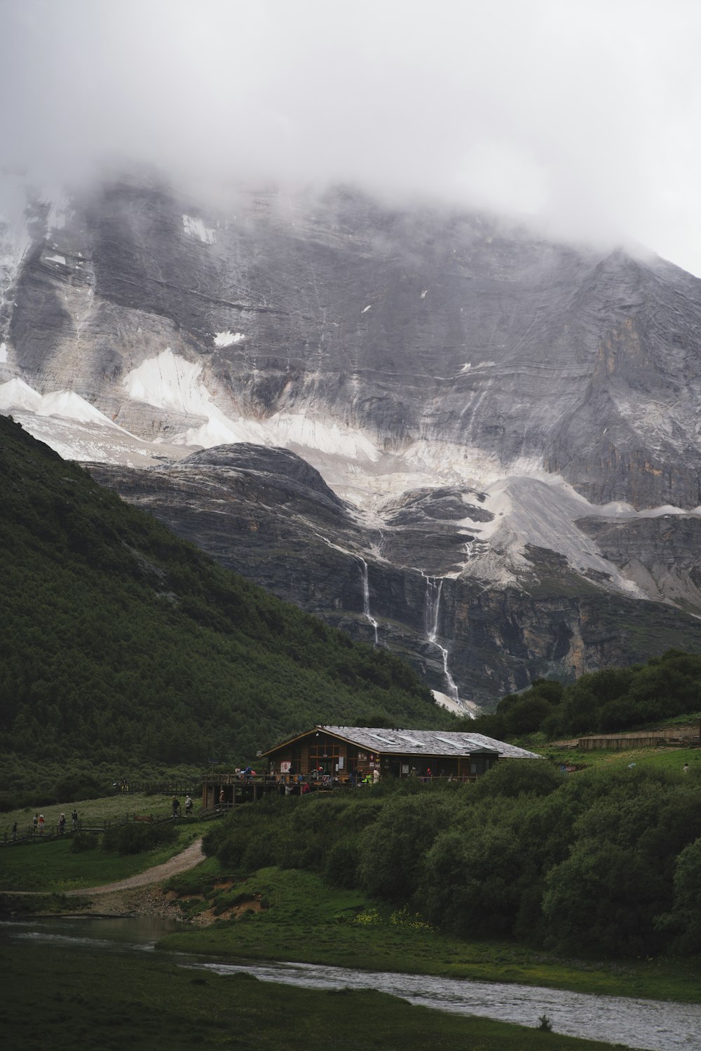 a mountain covered in snow next to a river