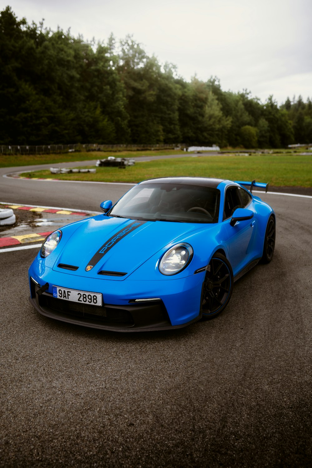 a blue sports car driving down a race track