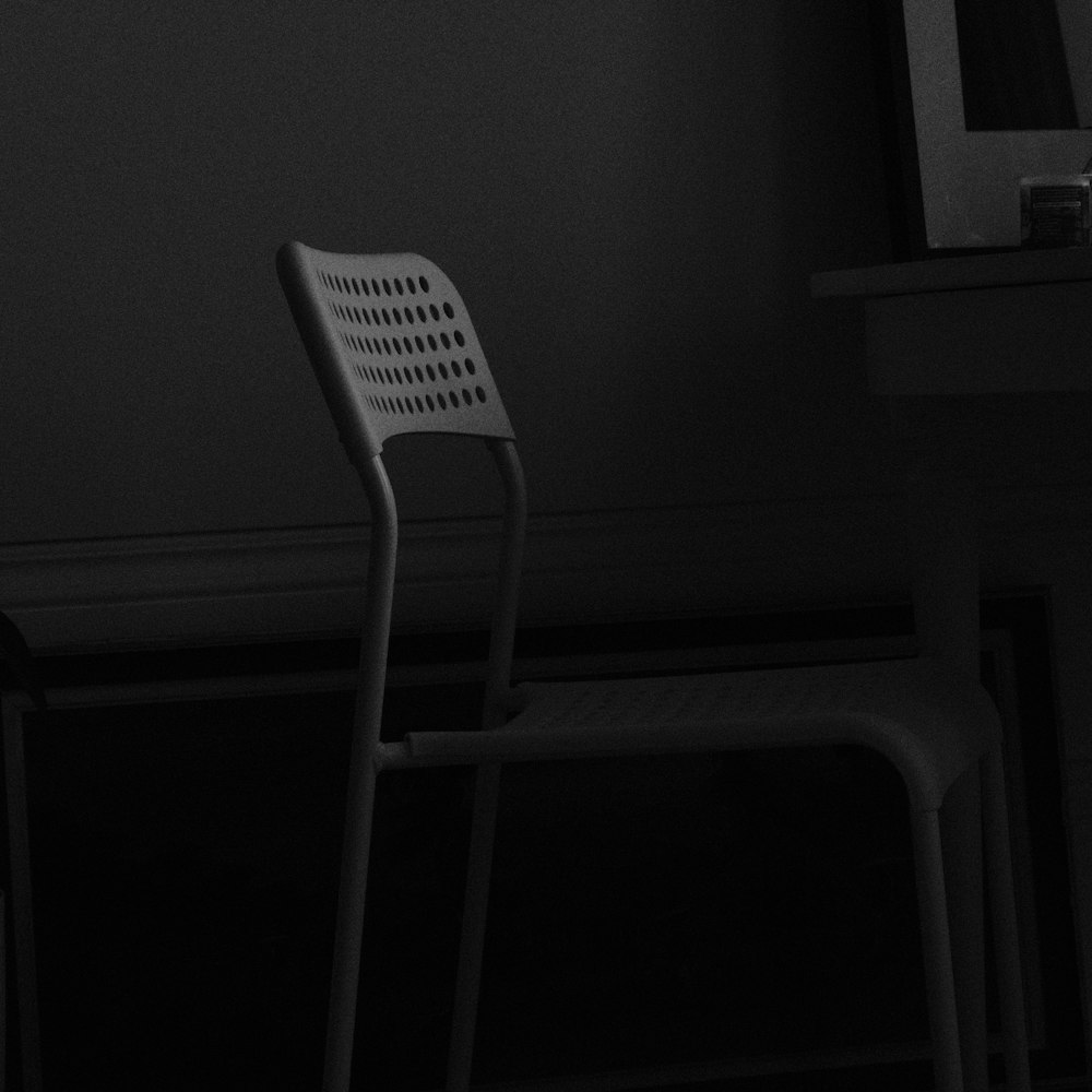 a black and white photo of a chair in a dark room