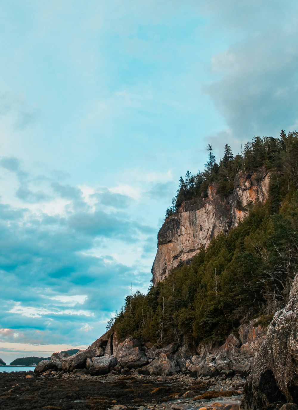 Ein Leuchtturm an einem felsigen Ufer mit blauem Himmel im Hintergrund