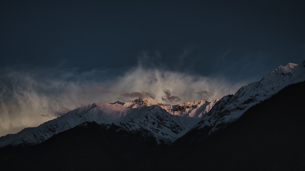 Ein schneebedeckter Berg unter einem bewölkten Himmel