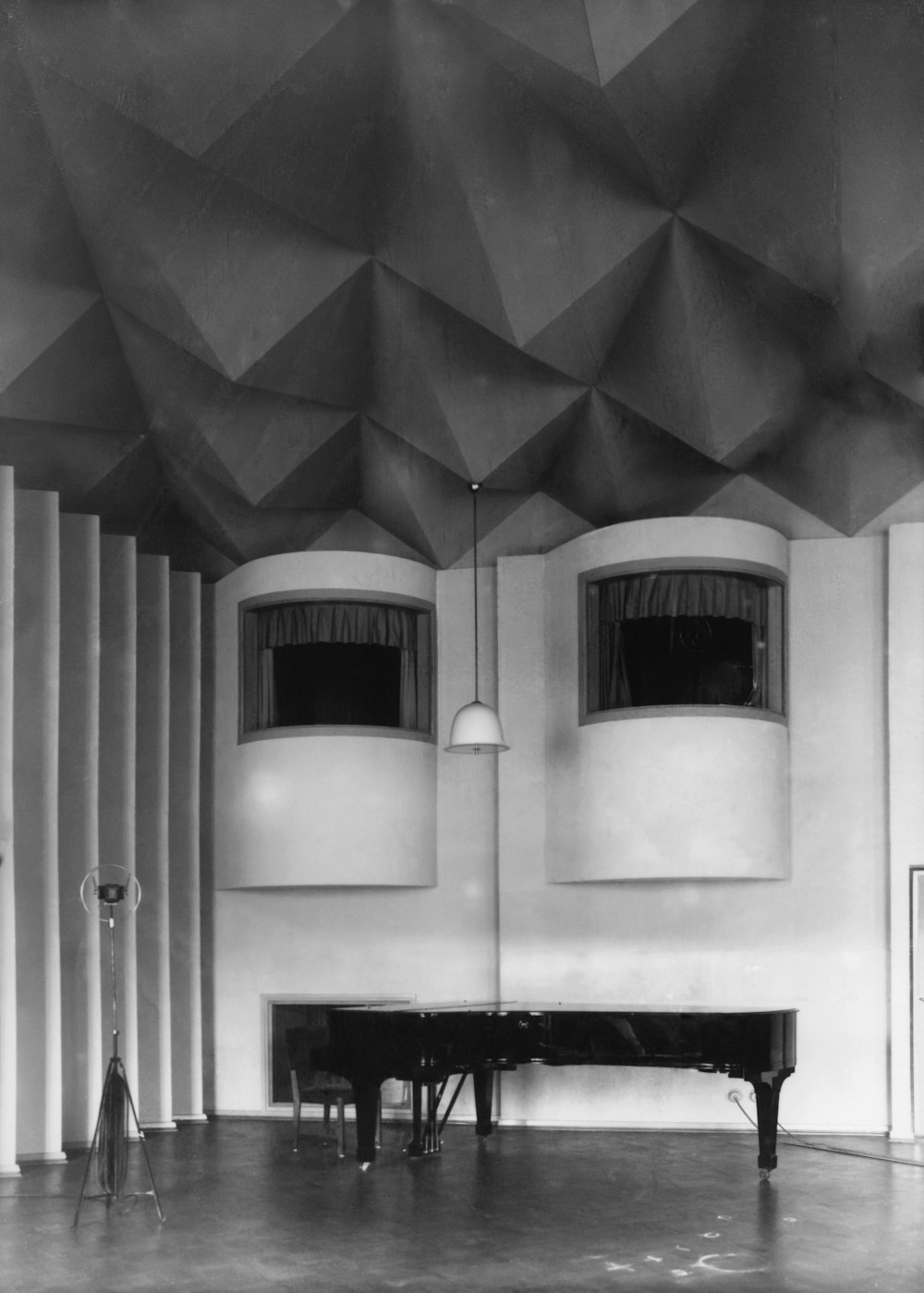 a black and white photo of a piano in a room