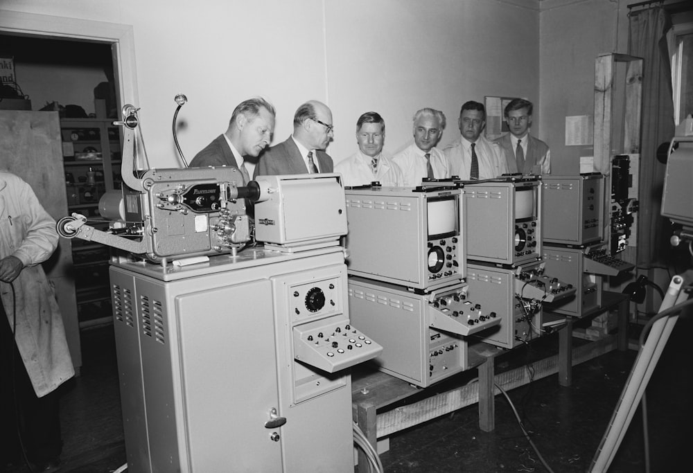 a group of men standing around a machine