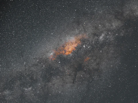 Close-up of a protostar surrounded by dense cosmic dust illuminated by soft light.
