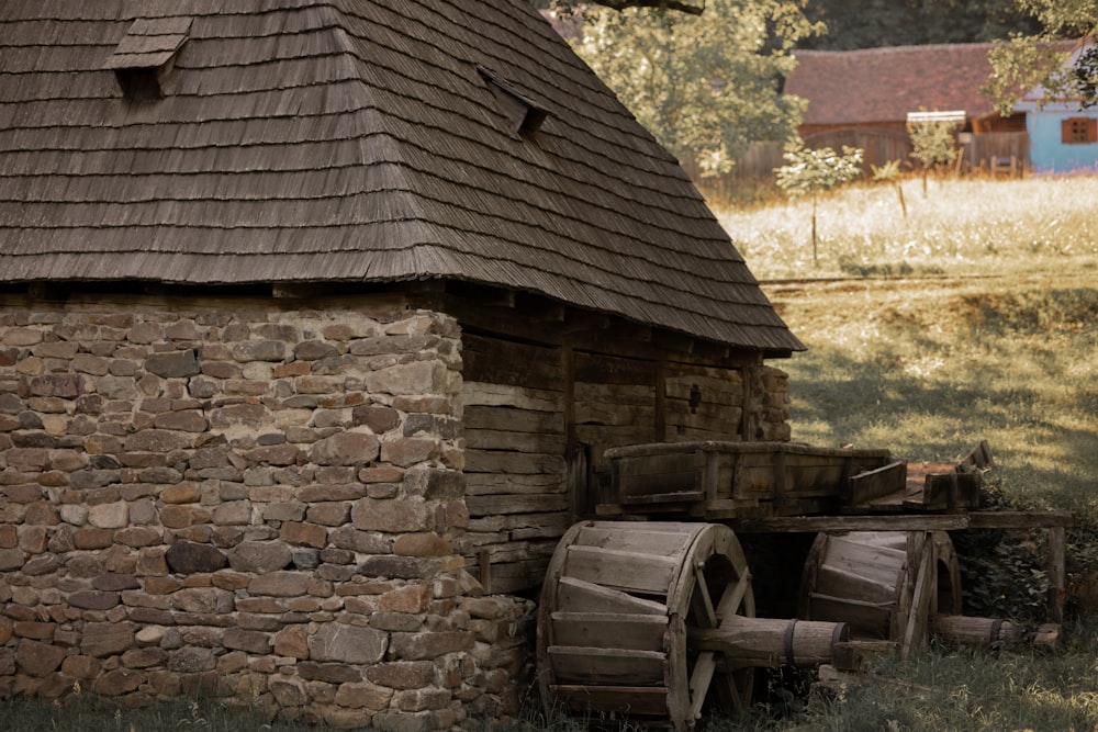 an old stone building with a water wheel in front of it