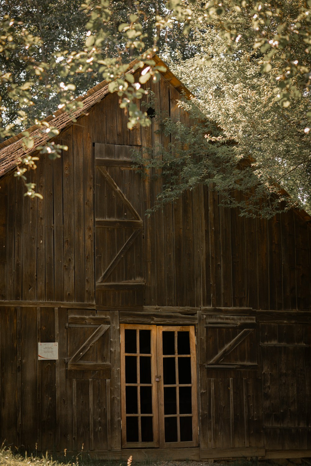 Un antiguo granero con una puerta y ventanas de madera