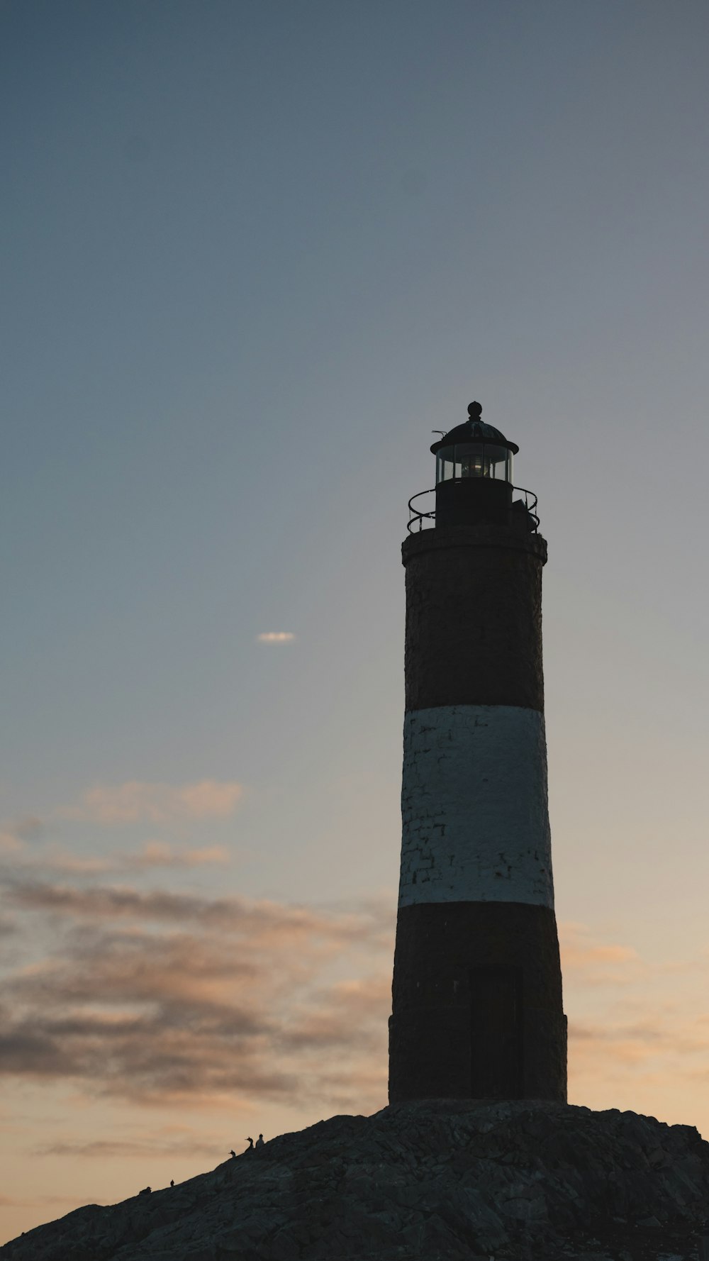 a lighthouse on top of a hill with a sky background