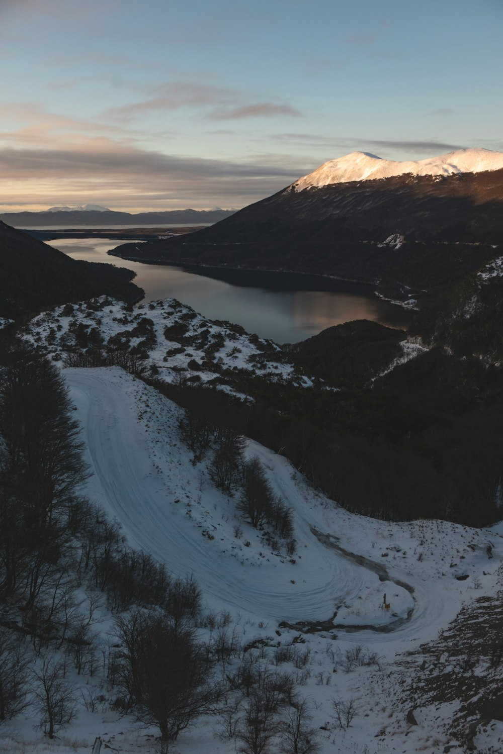 Un paesaggio innevato con un lago e montagne sullo sfondo