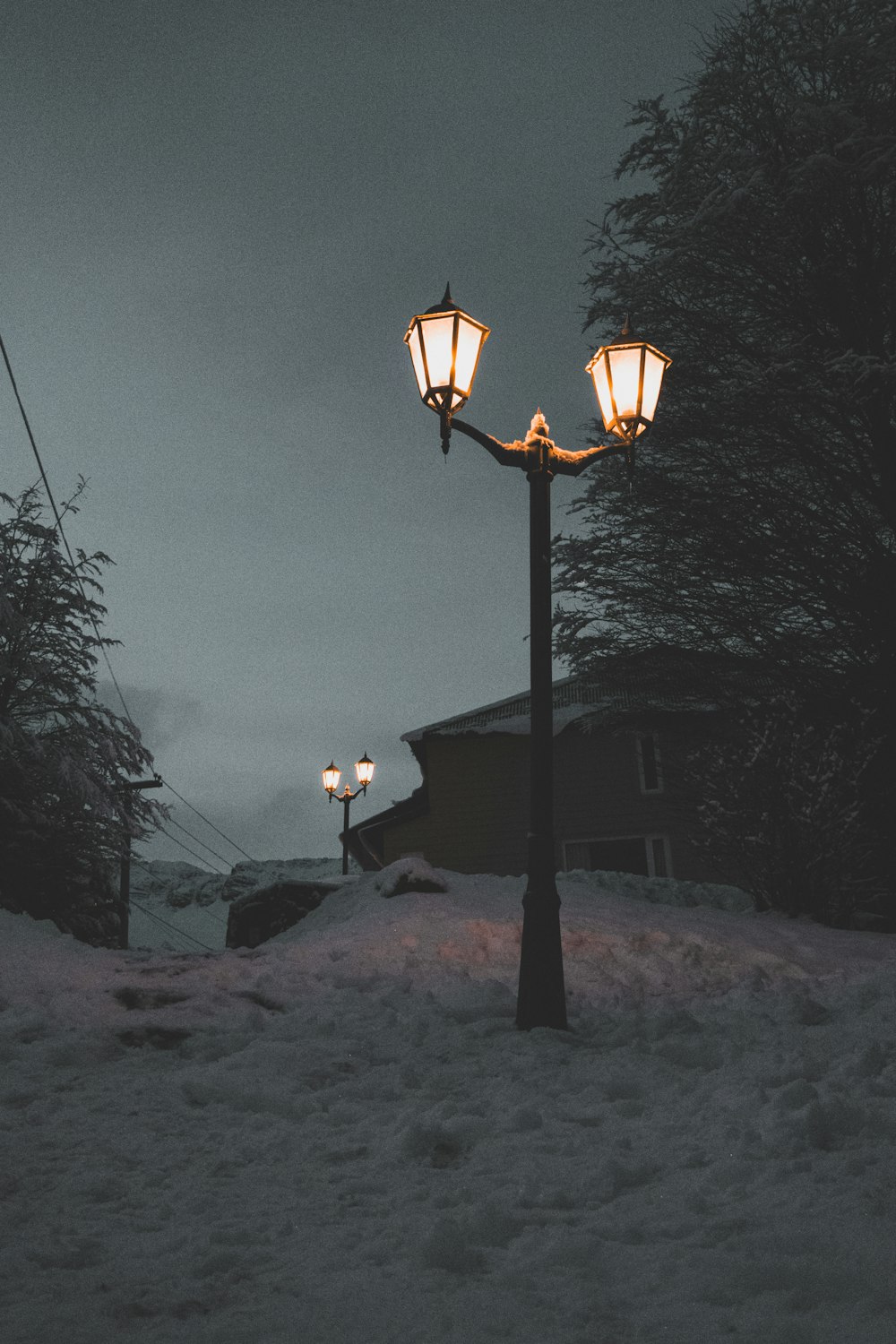 a street light in the middle of a snowy street