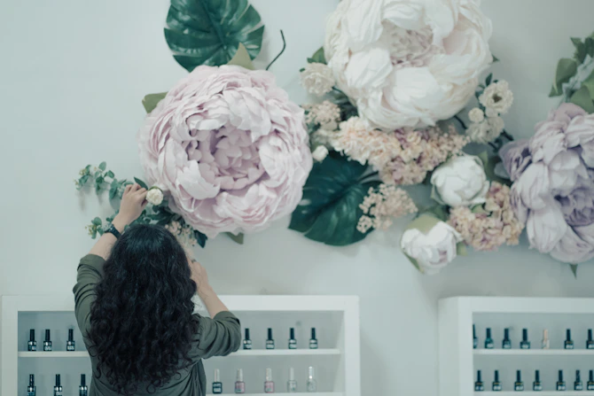a woman is arranging flowers on a wall
