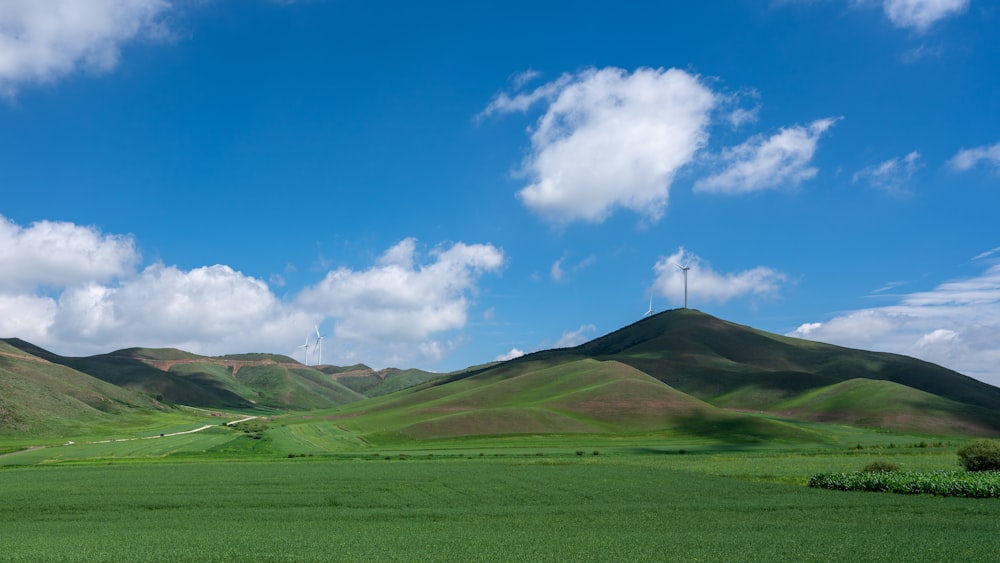 a green field with mountains in the background