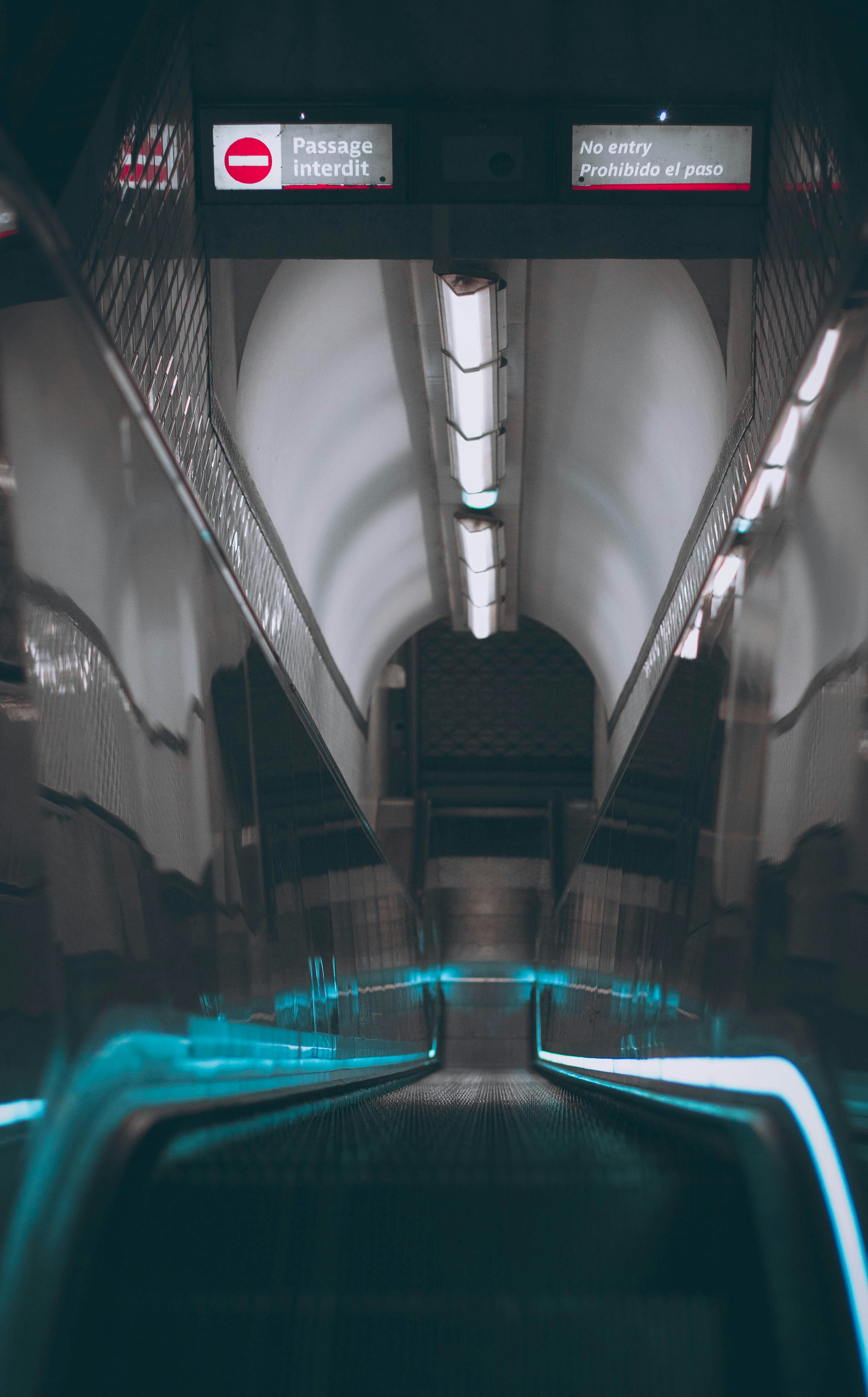 an escalator in a subway station with blue lights