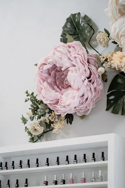 A cozy nail salon corner with soft green plants and pastel pink accents.