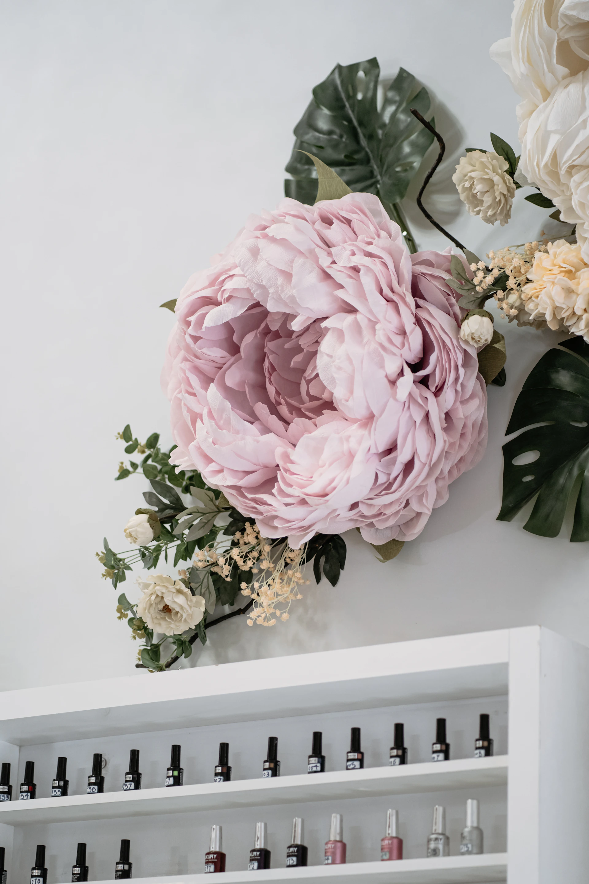 a large pink flower sitting on top of a white shelf