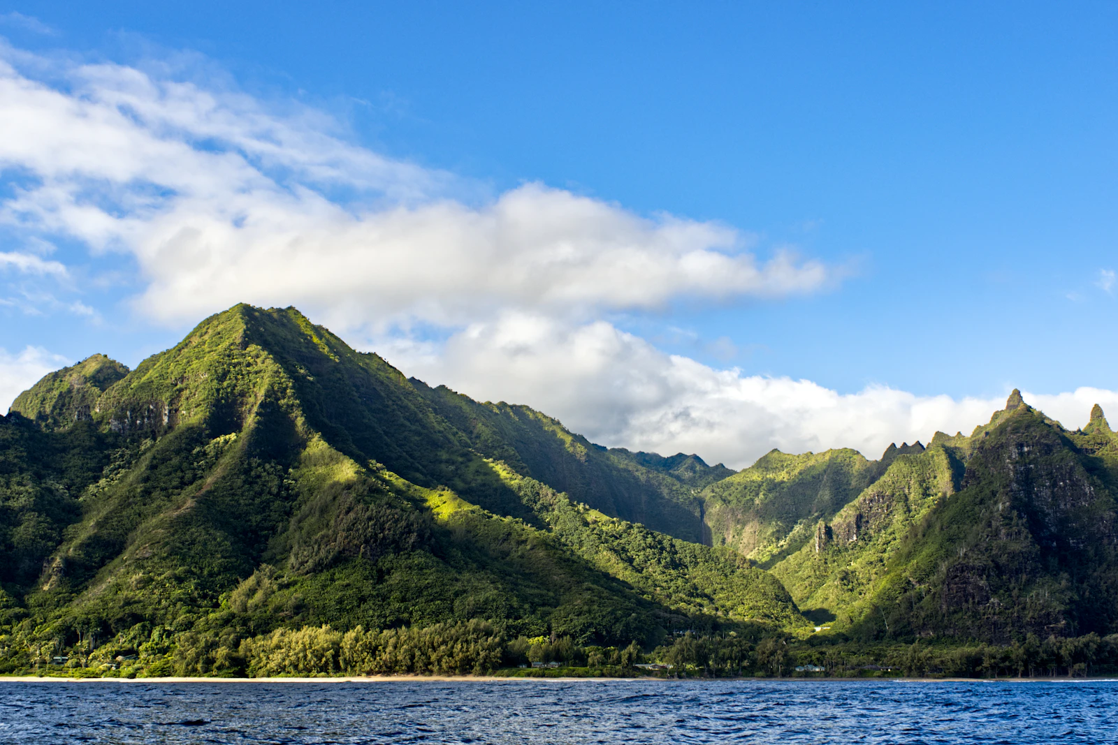 Green ridges of Kauai's Na Pali Coast meeting the Pacific Ocean