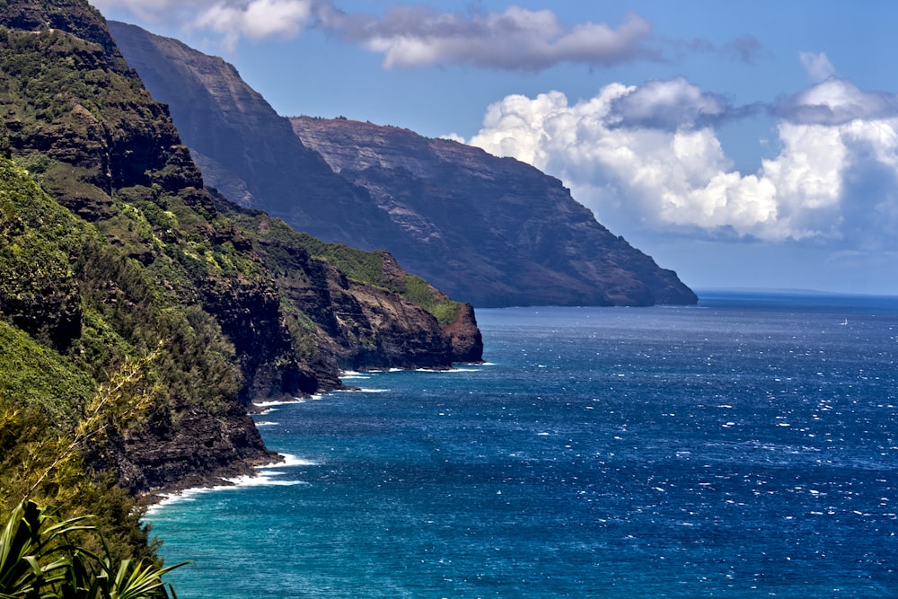 a scenic view of the ocean with a mountain in the background