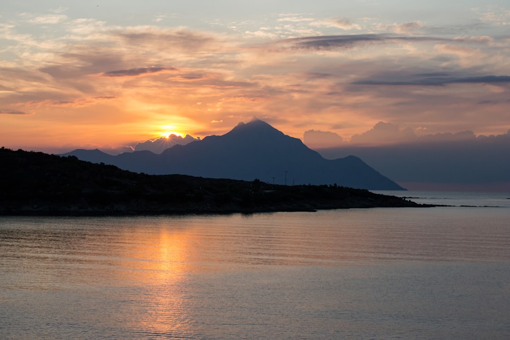 a large body of water with a mountain in the background