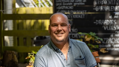 A calm business owner relieved from stress, smiling while checking reviews.