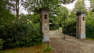 Private security gate with discreet, elegant design integrated into natural surroundings.