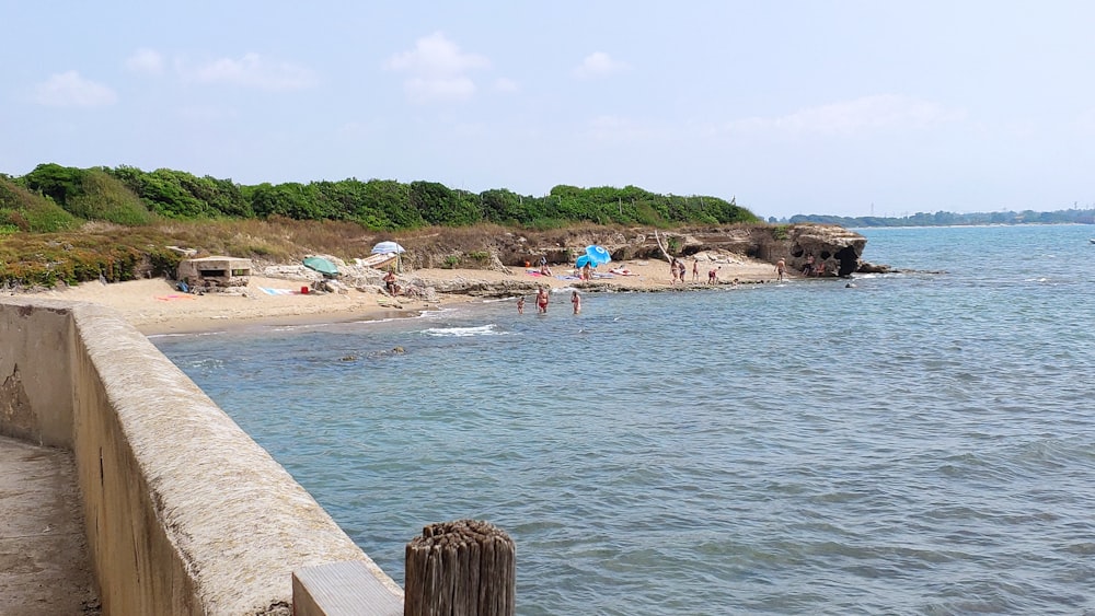 a sandy beach with people swimming in the water