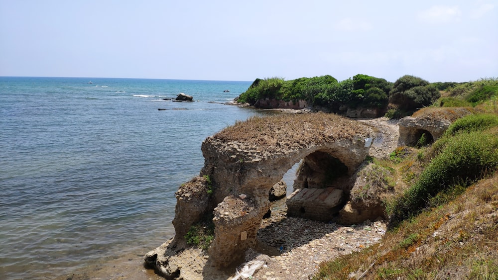 a rocky beach with a cave in the middle of it
