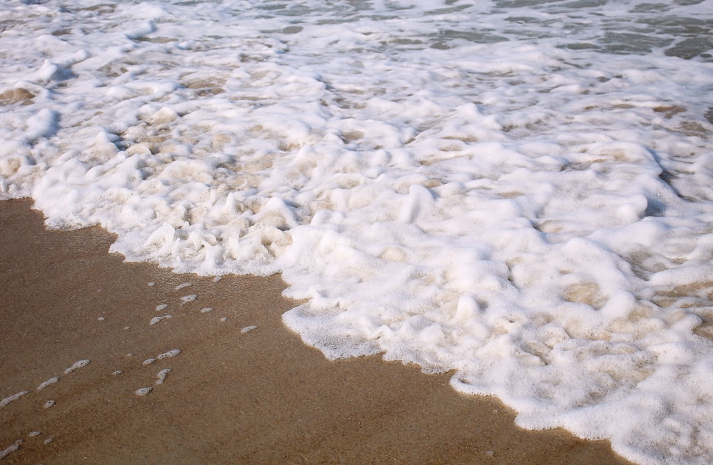 Una spiaggia sabbiosa con onde che entrano ed escono dall'acqua