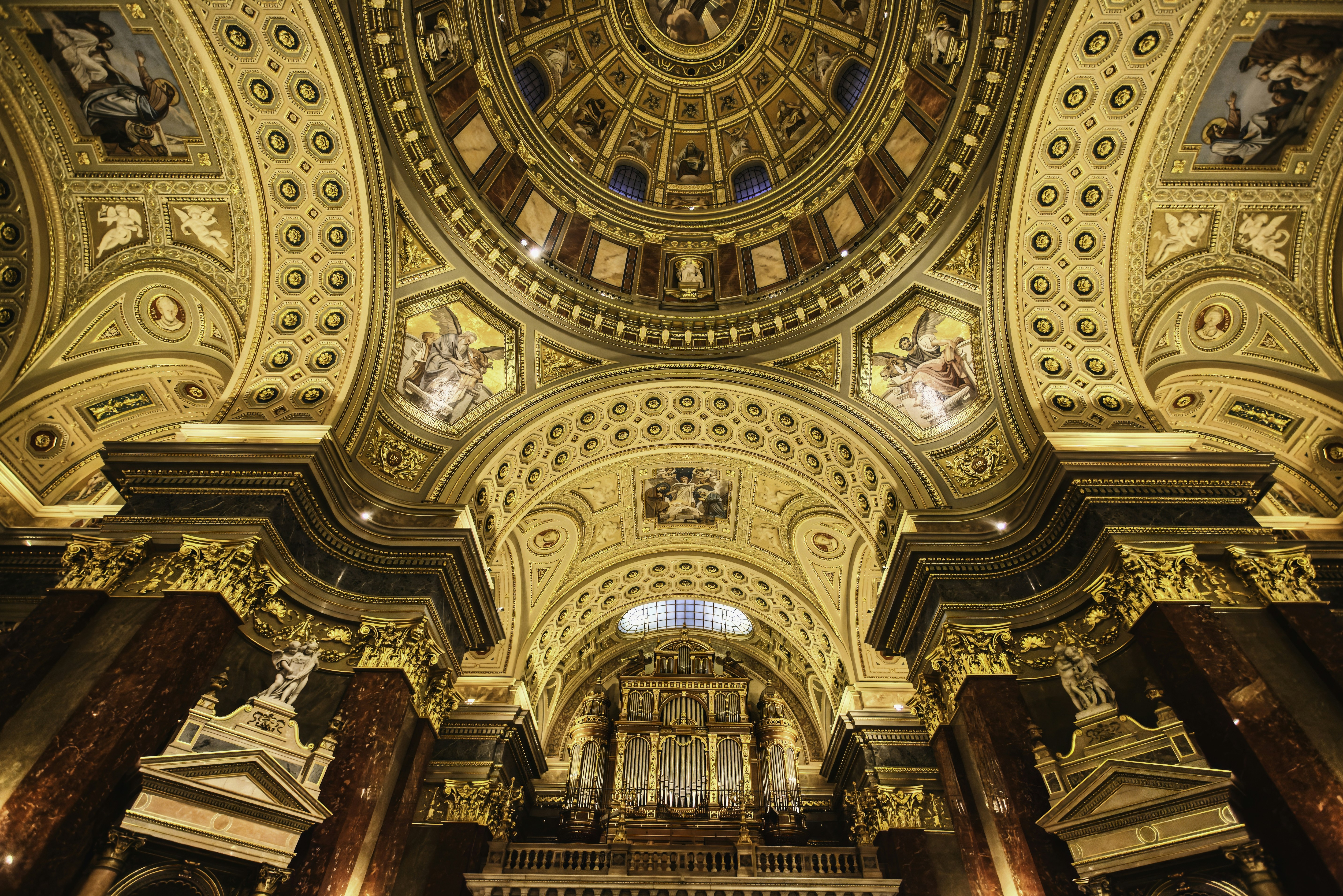 the ceiling of a large church with a clock on it