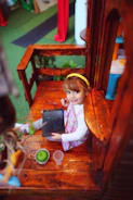 A cheerful child holding a tablet displaying a colorful digital activity book page.