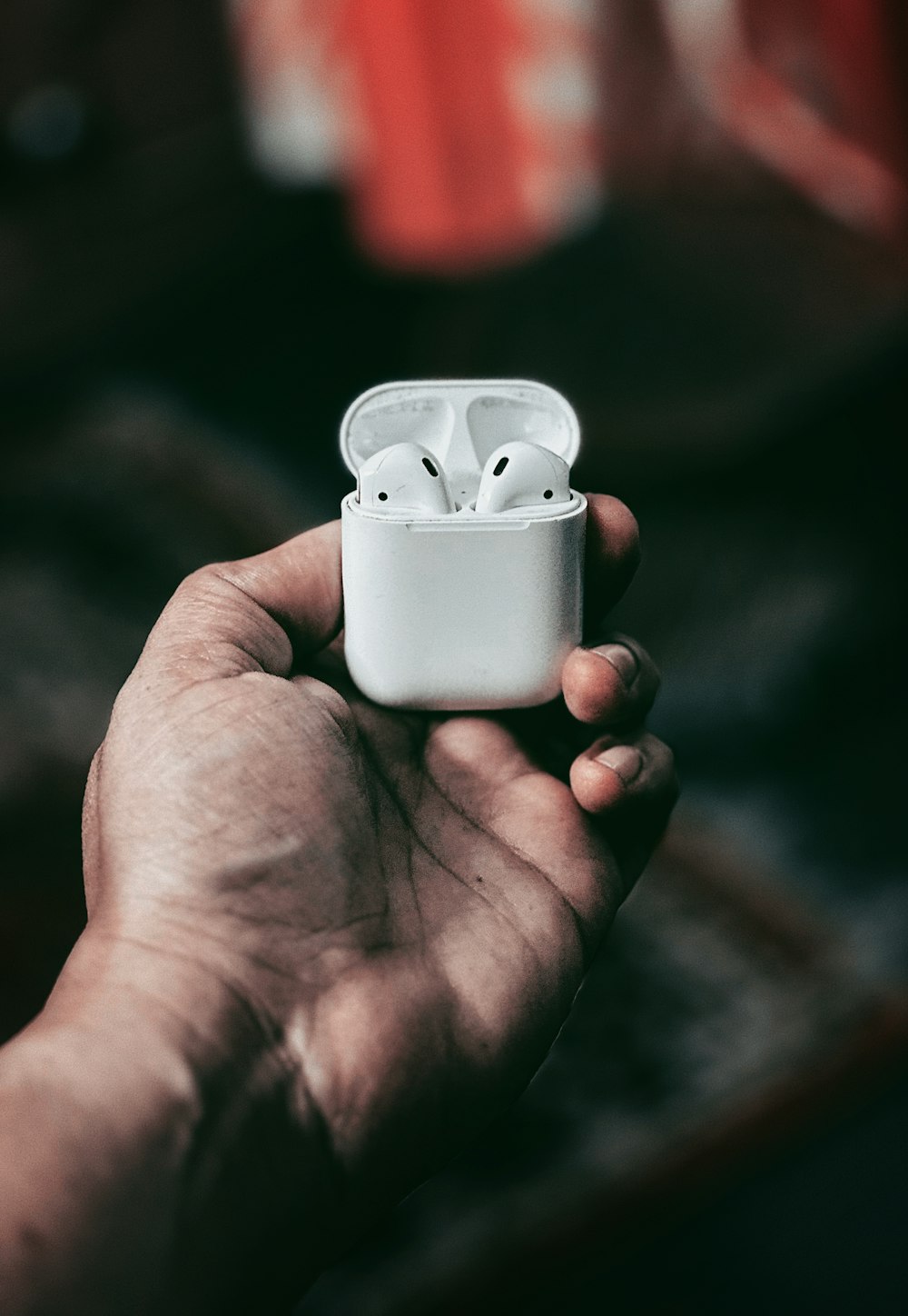 a person holding an airpods in their hand