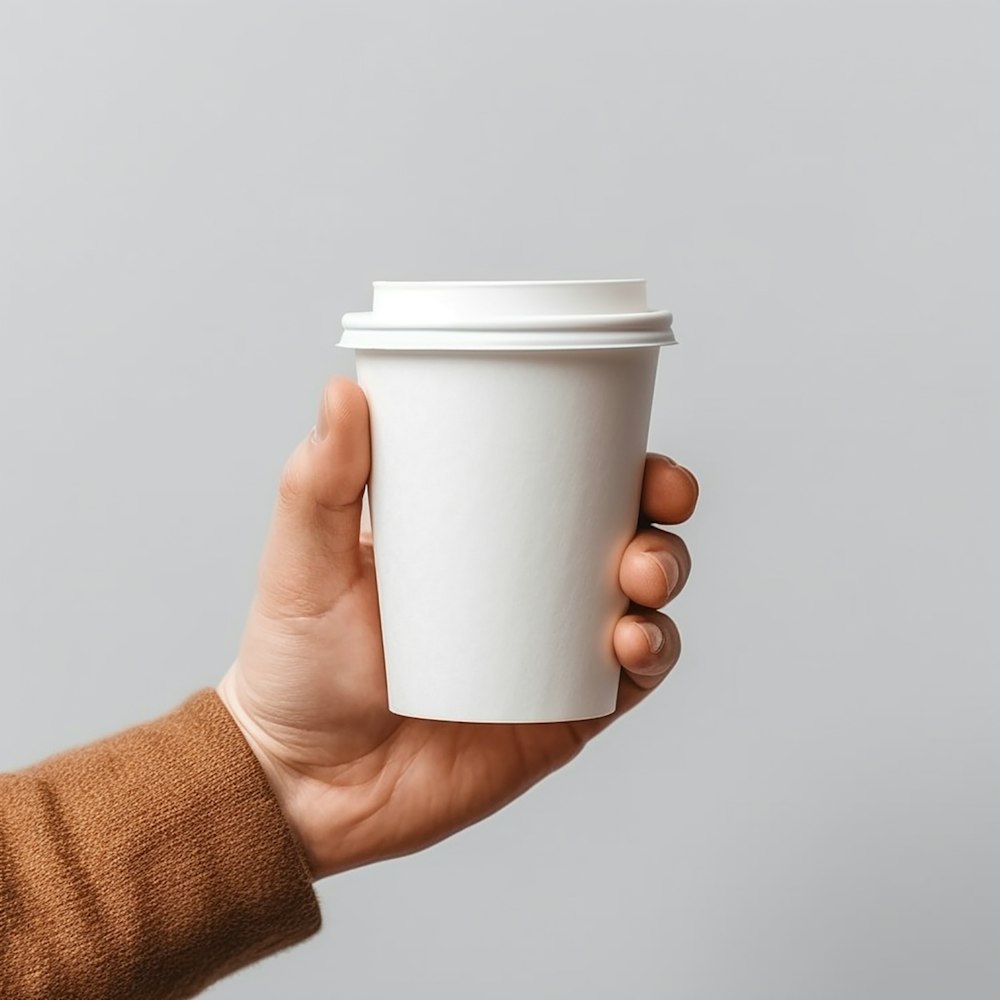 a person holding a cup of coffee in their hand