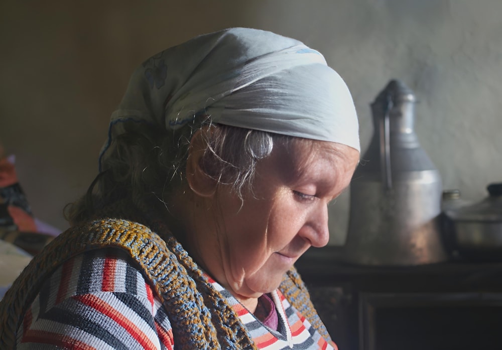 a woman with a head scarf on looking at a cell phone