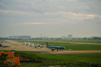 A panoramic view of an airport runway with planes lined up and ready.