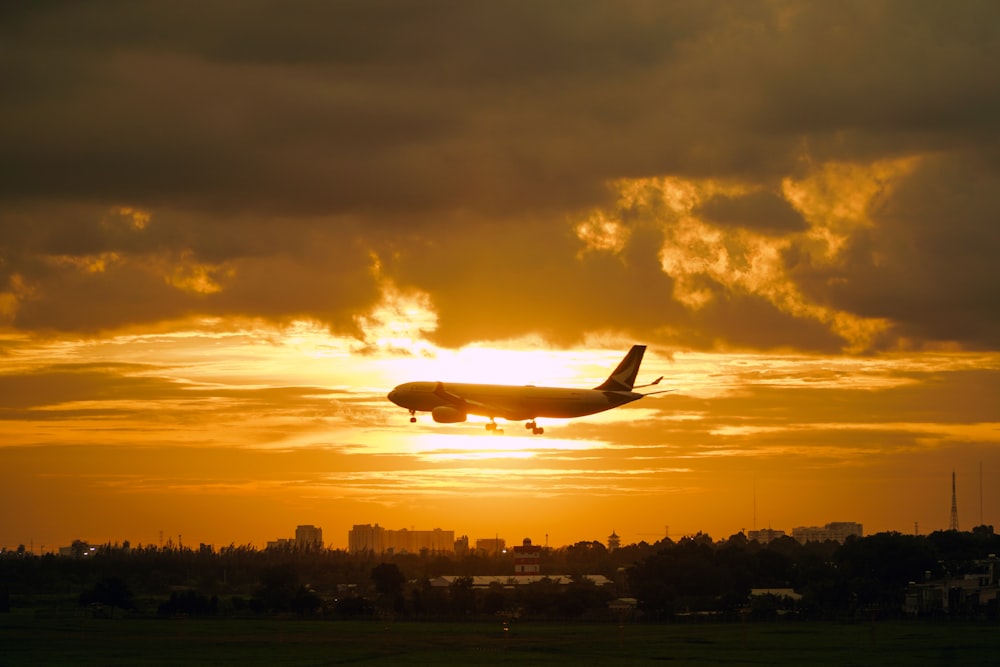 a plane is flying in the sky at sunset