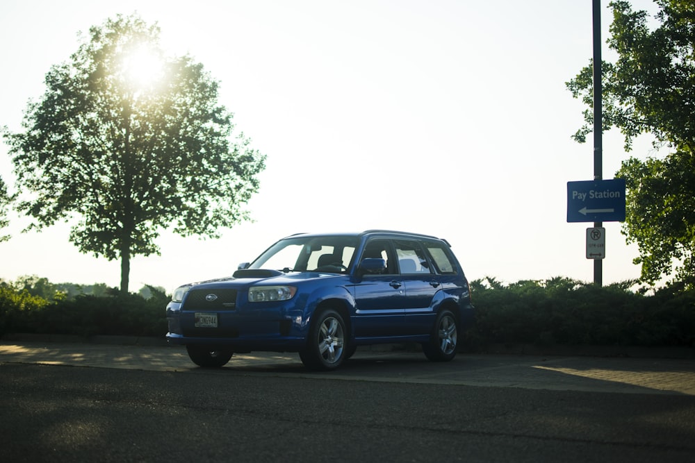 a blue suv parked on the side of a road