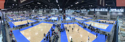 Modern indoor sports facility with people playing basketball and volleyball.