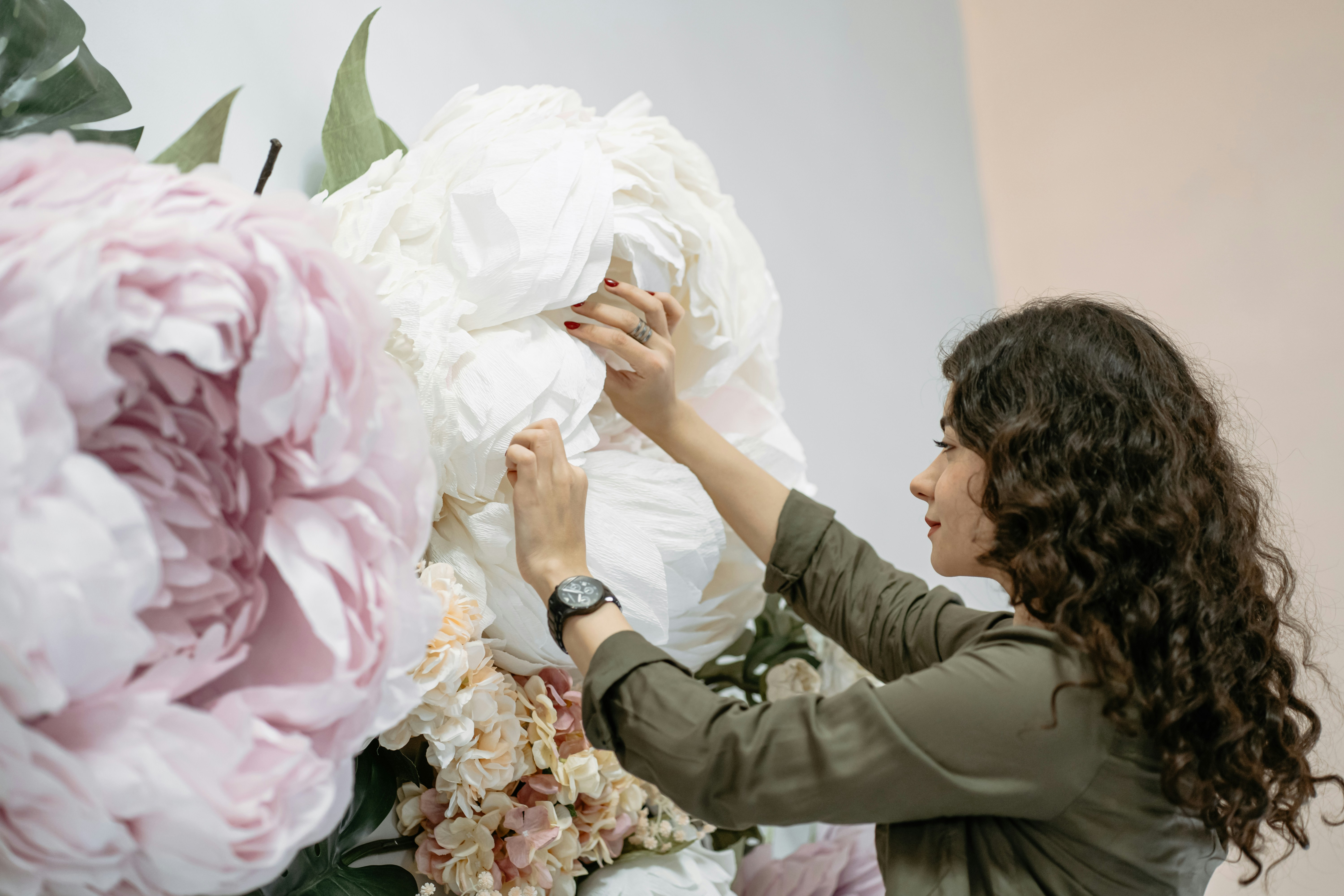 a woman working on a large flower arrangement