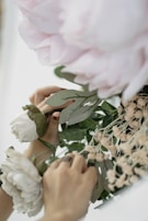 A smiling florist arranging flowers in a bright studio.