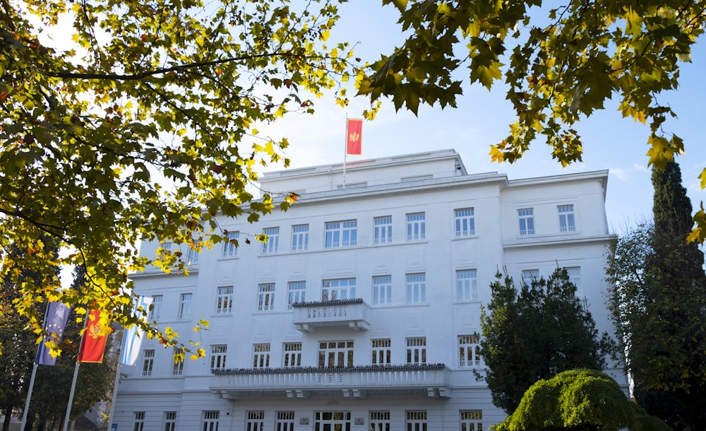 a large white building with a red flag on top of it