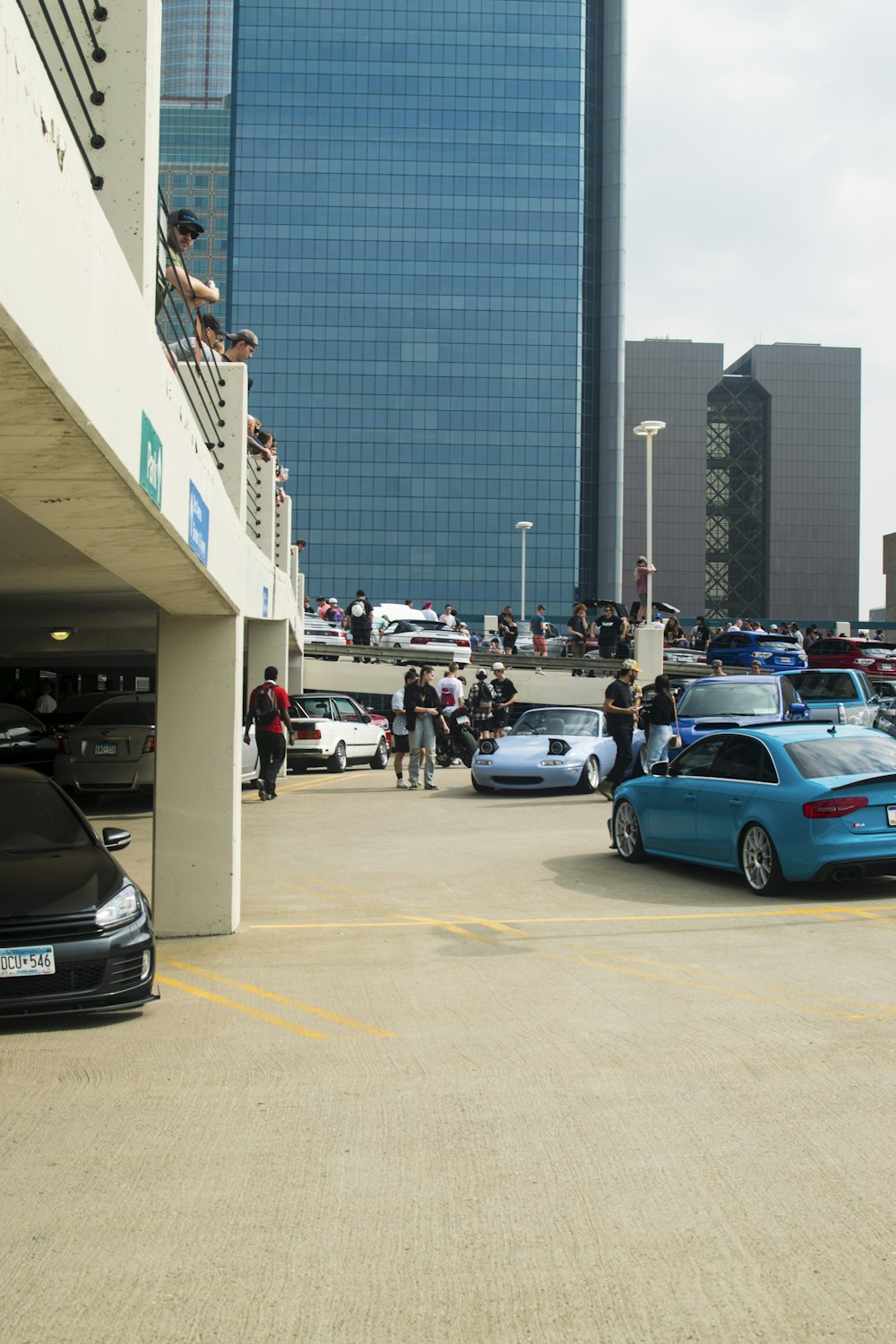 a parking lot filled with lots of cars next to tall buildings