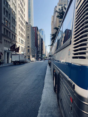 Vialume bus parked with city buildings in the background on a clear day.