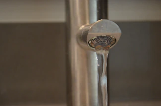 Close-up of a professional engineer installing a water-saving device on a modern faucet.