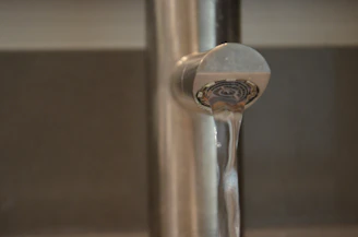 Close-up of a sleek chrome bathroom faucet with water flowing gently