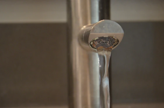A friendly technician fixing a leaky faucet in a cozy kitchen while smiling at the camera.