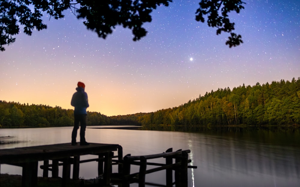 a person standing on a dock looking at the sky