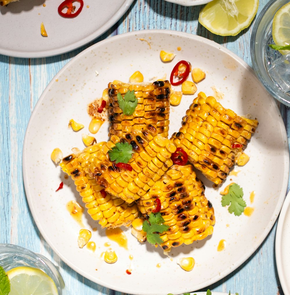 grilled corn on the cob on a white plate